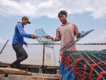 Two young men preparing traps for fishing